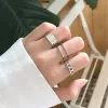 Three rings displayed together: one silver, one gold, and one rose gold. All rings have an open, adjustable band design.