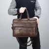 This brown leather briefcase features a vintage aesthetic with brass clasps and a worn finish.