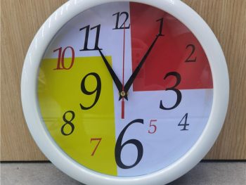 A sleek digital wall clock with a minimalist design against a white background.