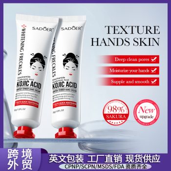 Woman applying kojic acid hand cream at her office desk during work