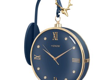 Modern blue wall clock with gold Roman numerals and a deer antler detail.