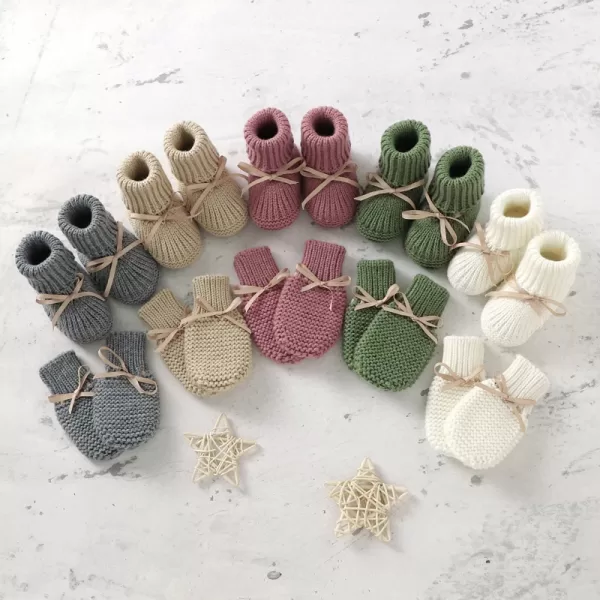 Close-up photo of pink knit baby booties and mittens