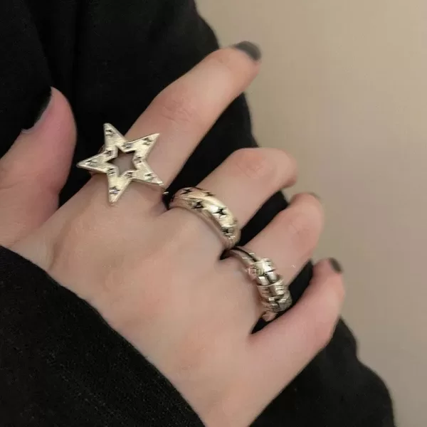 A close-up photo featuring several Women's Open Star Metal Rings stacked together on a finger.