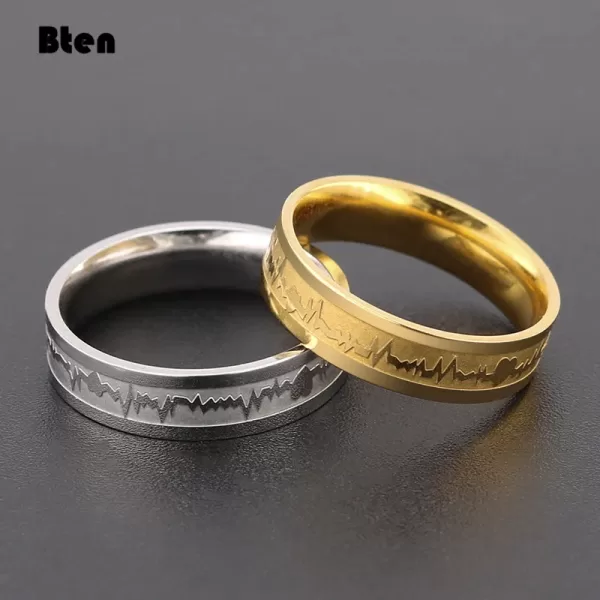 Close-up photo of two stainless steel couple rings, gently leaning against each other. The women's ring features a (describe design element), while the men's ring showcases a Celtic dragon design.