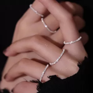A photo featuring a collection of delicate finger rings for women, including thin bands, stacking rings with intricate details, or birthstone rings.