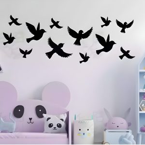 A flock of wooden birds in various shapes and sizes gracefully flies across a white wall.