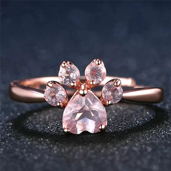 Close-up photo showcasing an adjustable rose gold ring featuring a cute bear paw design embellished with sparkling pink crystals.