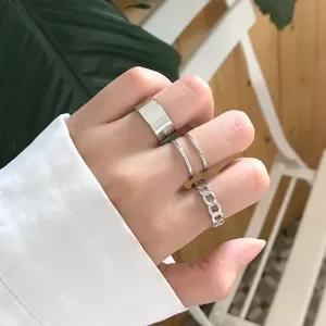 Three rings displayed together: one silver, one gold, and one rose gold. All rings have an open, adjustable band design.