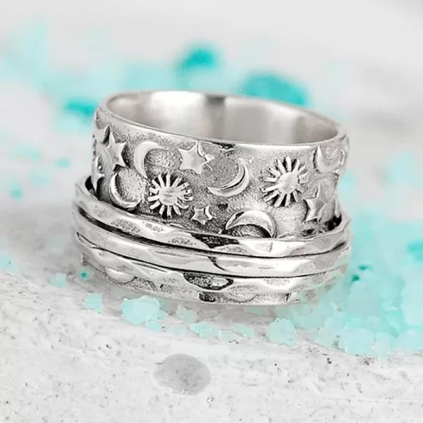 Close-up photo of the Huitan ring on a woman's hand, showcasing the detailed carvings of the sun, moon, and star symbols.