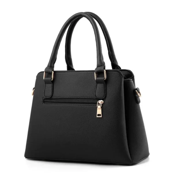 Black leather handbag with a tassel accent, gold chain strap, and clasp closure.