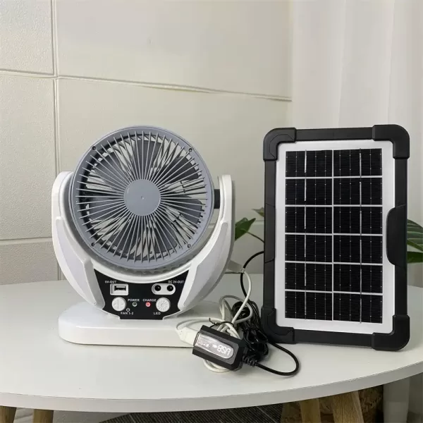 A sleek, modern table fan with a solar panel sits on a desk, blowing cool air.