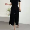A black knitted midi dress styled with sandals, creating a perfect summer outfit.