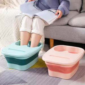 A person relaxes with their feet in a folded footbath filled with warm water and bath salts.