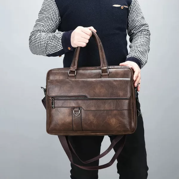 This brown leather briefcase features a vintage aesthetic with brass clasps and a worn finish.