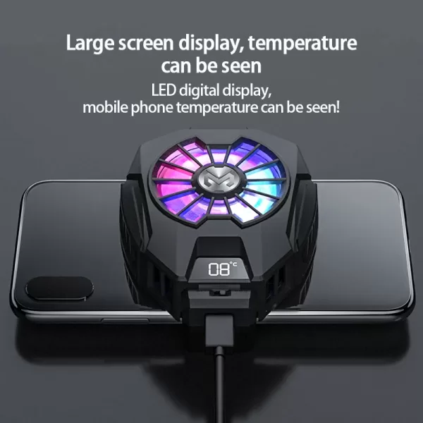 Close-up of a phone cooler showing the spinning fan blades with a blurred mobile phone in the background.