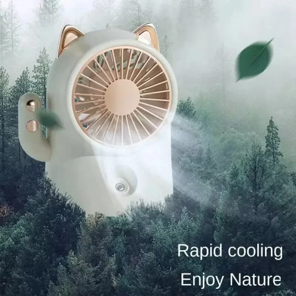 A person holds a portable table misting fan outdoors on a hot day, with a refreshing mist spraying from the fan.