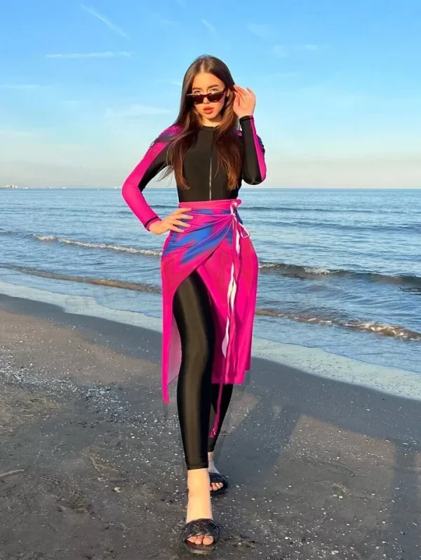 Group of Muslim women wearing Burkinis laughing and enjoying themselves at the beach.