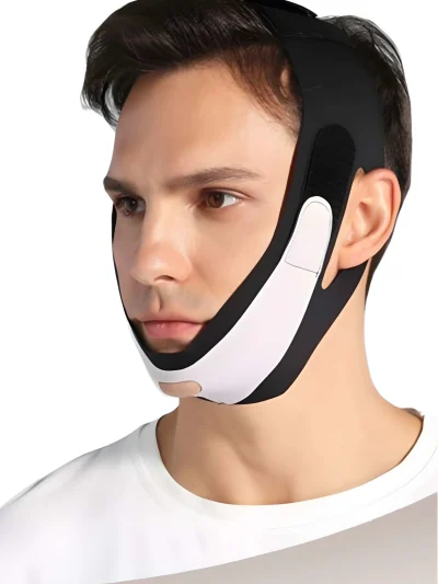 Side angle shot of a man wearing a black and white V-line face slimming chin strap showing the ear cutouts and adjustable velcro straps wrapped around the head.