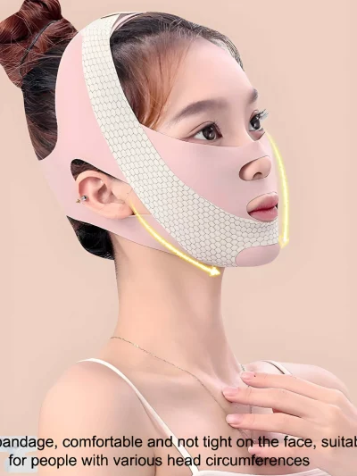 A woman wearing a light pink V-line face slimming bandage strap with textured white mesh panels across the chin, cheek, and crown areas, ear cutouts, and openings for the nose and mouth.