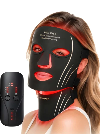 Woman wearing a flexible black LED face and neck beauty mask emitting red illumination next to a black handheld remote control on a plain white background.