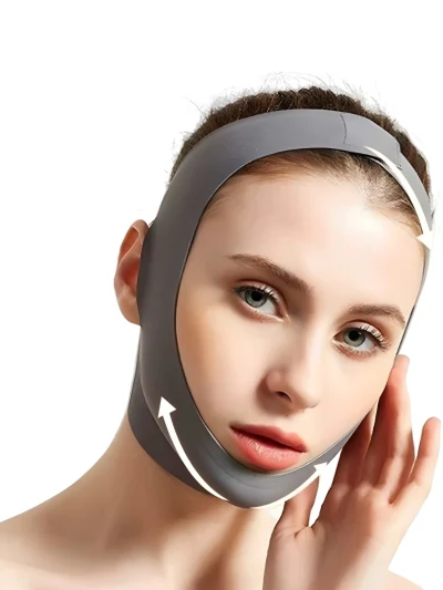 A woman wearing a dark grey V-line face slimming lifting mask strap wrapped around her chin, jawline, and top of the head with white directional arrows on a plain white background.