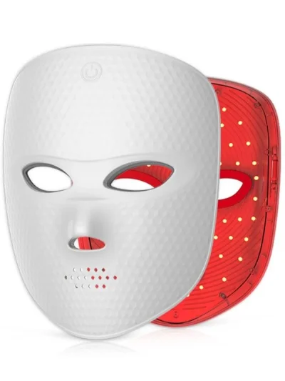 White textured facial LED light therapy mask shown from the front with eye and nose openings, power button symbol on the forehead, and ventilation holes on the chin alongside an inner red shell lined with LED light nodes.