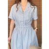 Close-up of button pockets on striped lapel shirt dress