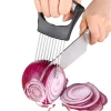 Onion holder and slicer in use, hands slicing red onion with a knife guided by a stainless steel onion holder.