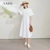 Model wearing AMII backless summer office dress in light color, standing in office environment (3).