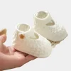 Infant wearing soft knit shoes baby girl prewalker on an indoor floor (3).