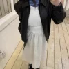 Woman in a flowy Cordelia long skirt walking through a spring garden (1).