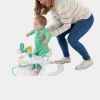 Smiling baby sitting in a Fisher-Price Sit-Me-Up Chair with snack tray on a colorful floor (2).