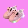 Children playing outdoors wearing colorful LED light-up sneakers shoes with glowing soles (2).