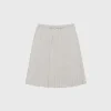 Woman wearing a dark jacquard pleated skirt in spring outdoor setting (1).