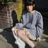 Woman in Korean plaid balloon-sleeve shirt and mini skirt set posing outdoors in spring (1).