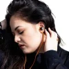 Orange LUDOS Ultra USB-C headphones with magnetic earbuds shown beside iPhone and Samsung device (1).