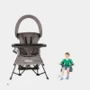 Baby chair seated in a grey portable chair with sun canopy, designed for indoor and outdoor use (2).