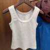 Woman wearing RE*TO 2025 retro tank top outdoors on a sunny day (3).